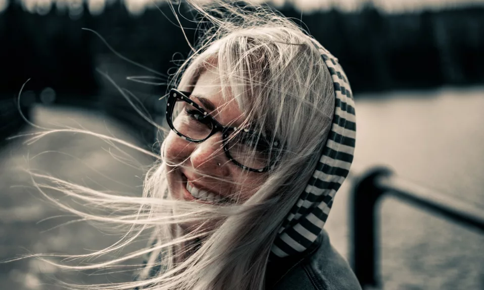 Femme souriante avec des lunettes en plein air.