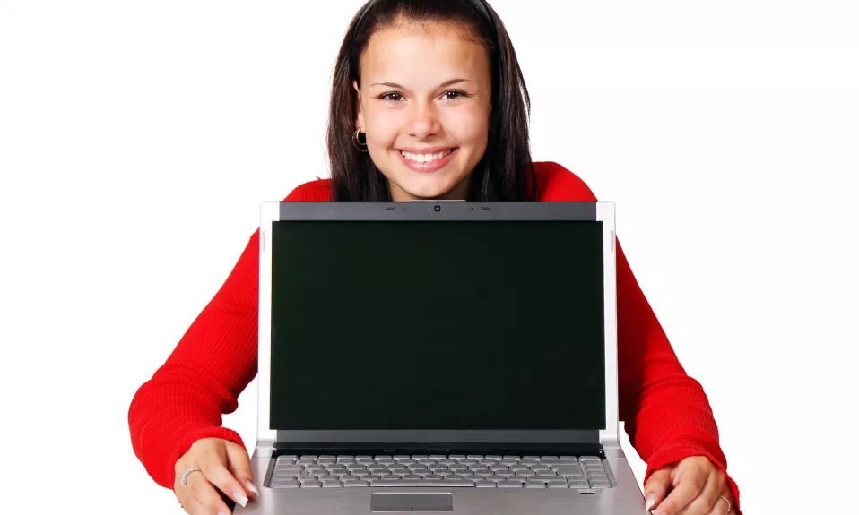 Jeune souriante avec ordinateur portable écran vide.