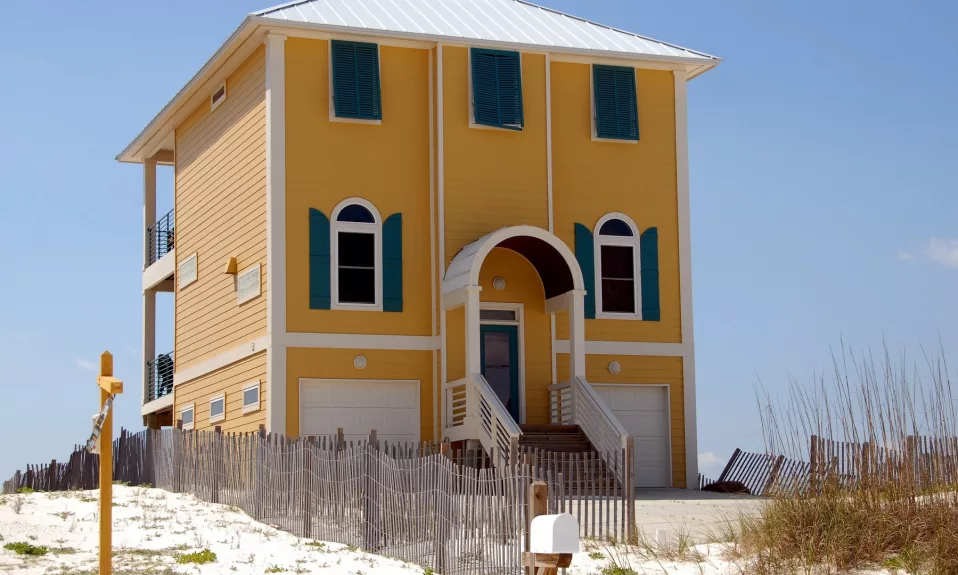 Maison jaune plage sable dunes ciel bleu
