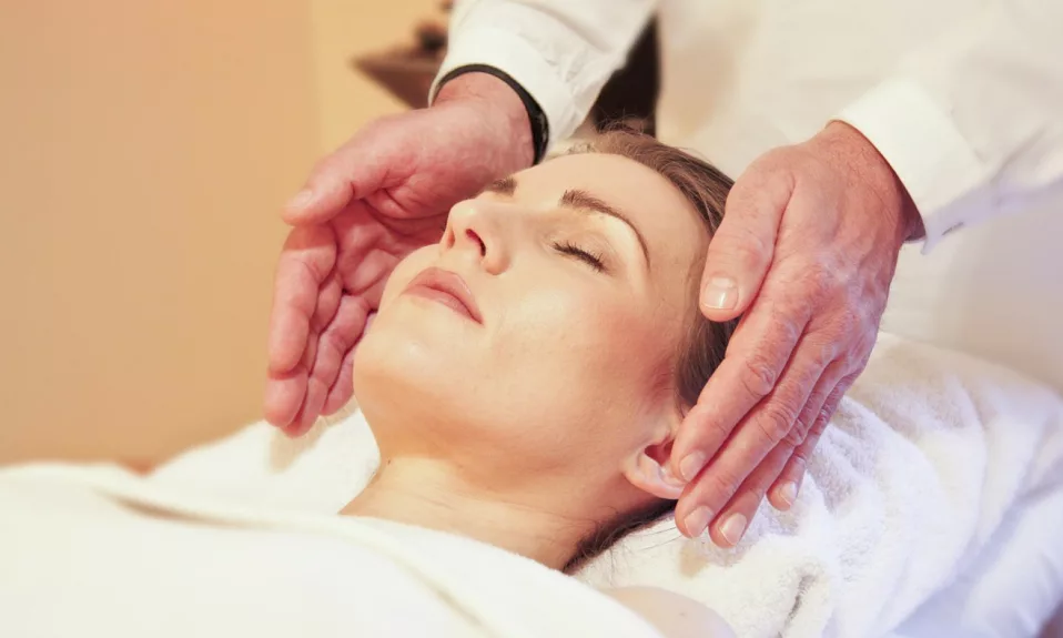 Femme recevant un massage facial relaxant.